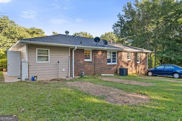 rear view of property with a lawn and central AC