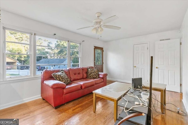 living room featuring wood-type flooring, plenty of natural light, and ceiling fan