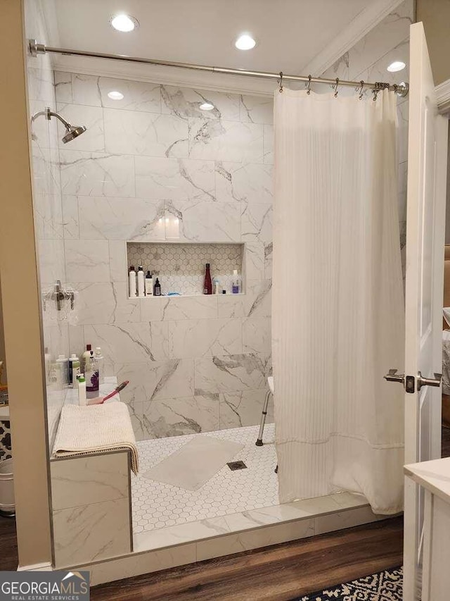 bathroom featuring walk in shower, hardwood / wood-style flooring, and ornamental molding