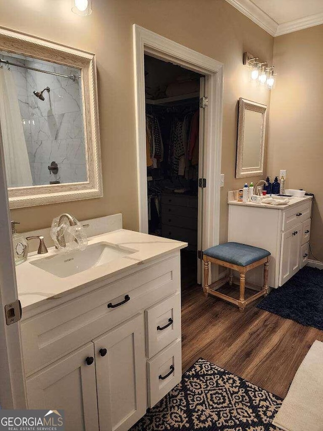 bathroom with a shower, hardwood / wood-style floors, vanity, and crown molding