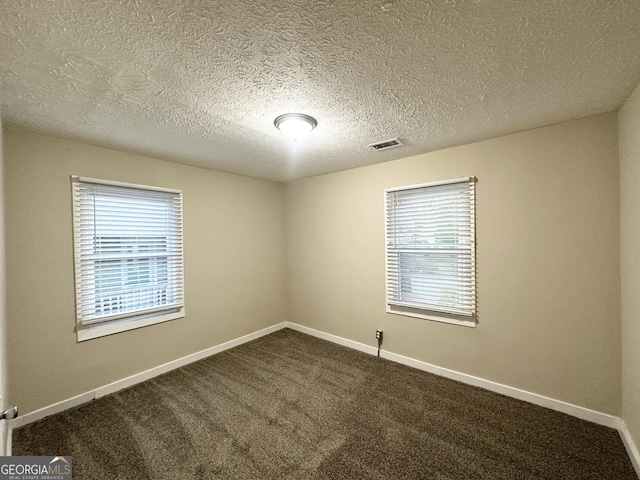 unfurnished room featuring carpet floors and a textured ceiling