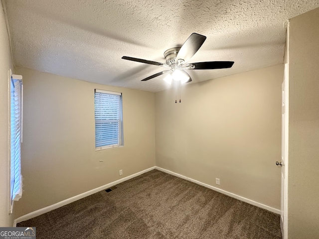 empty room with ceiling fan, carpet, and a textured ceiling