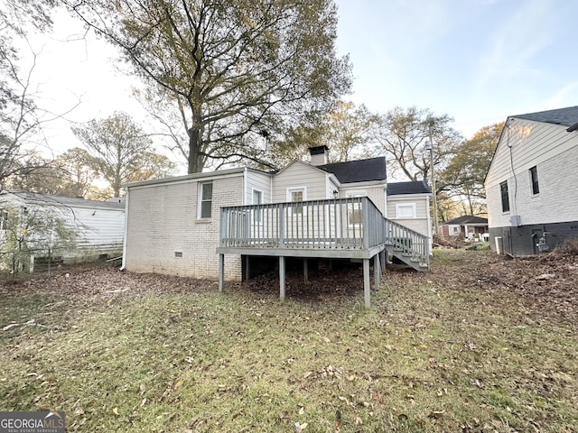 back of house featuring a lawn and a deck