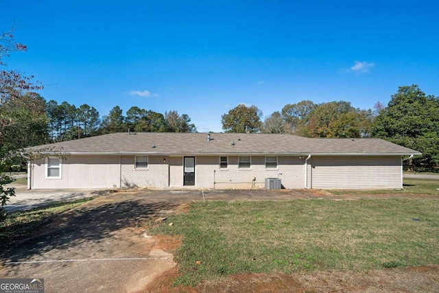 back of property with a yard and central AC unit