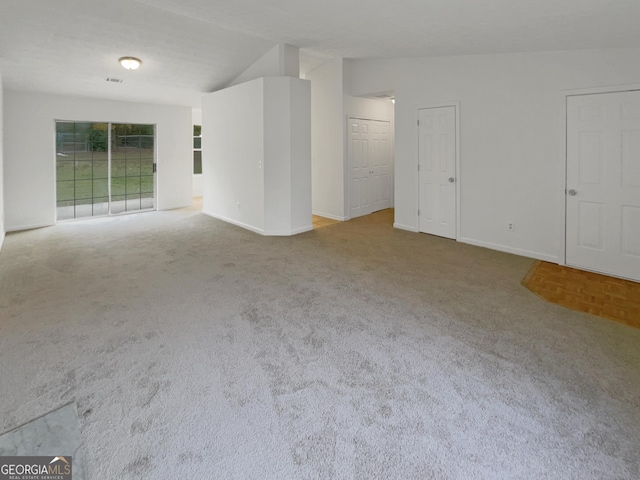 carpeted spare room featuring lofted ceiling