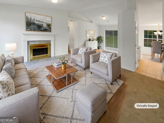 living room featuring a fireplace, light tile patterned floors, and vaulted ceiling