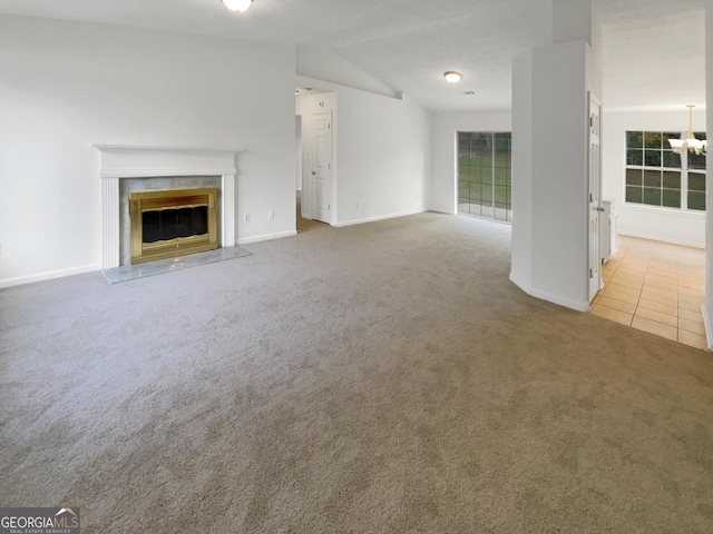 unfurnished living room featuring a fireplace, light colored carpet, and lofted ceiling