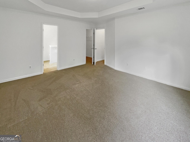 carpeted spare room with a tray ceiling