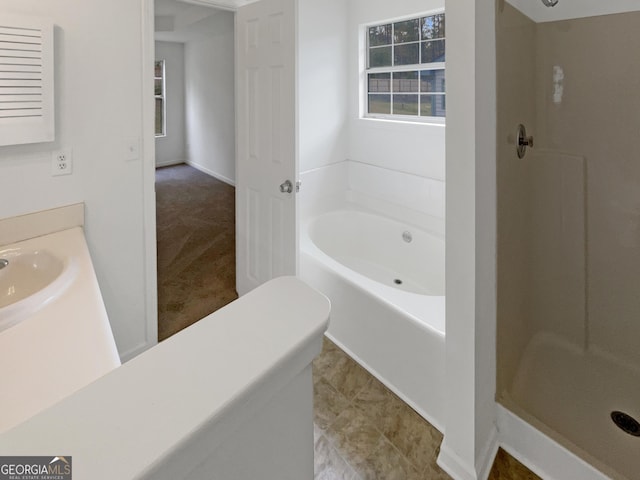 bathroom featuring shower with separate bathtub and sink