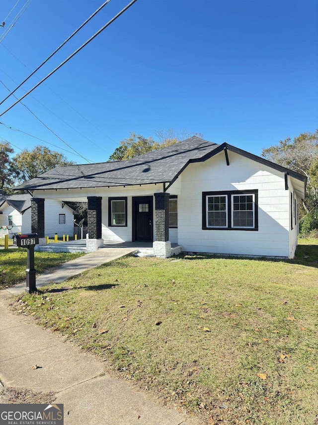 ranch-style home featuring a front lawn and a porch