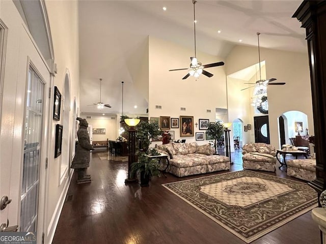 living room featuring dark hardwood / wood-style flooring, high vaulted ceiling, and ceiling fan