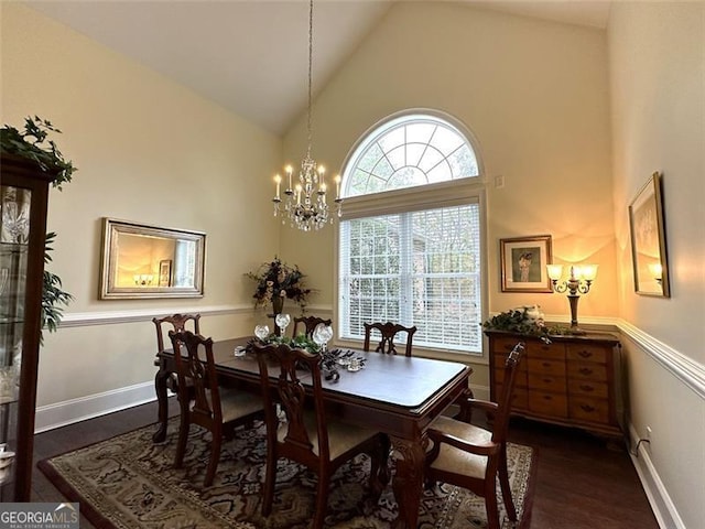 dining space with an inviting chandelier, high vaulted ceiling, and dark wood-type flooring