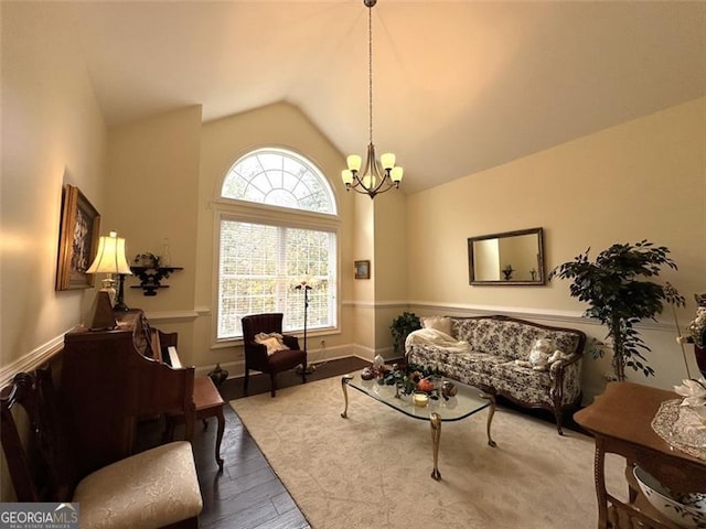 living room featuring a notable chandelier, light hardwood / wood-style floors, and vaulted ceiling