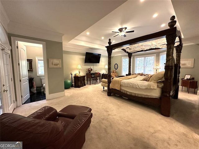 bedroom with ceiling fan, light colored carpet, ornamental molding, and connected bathroom