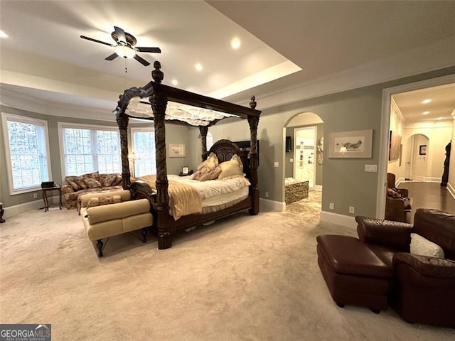 carpeted bedroom featuring ensuite bath, ceiling fan, and ornamental molding