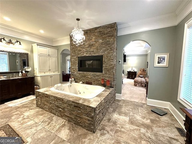 bathroom with tiled bath, crown molding, and vanity