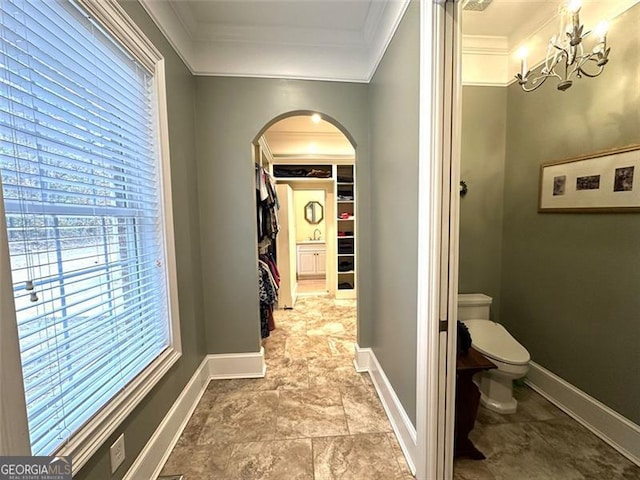 hall with crown molding and a notable chandelier