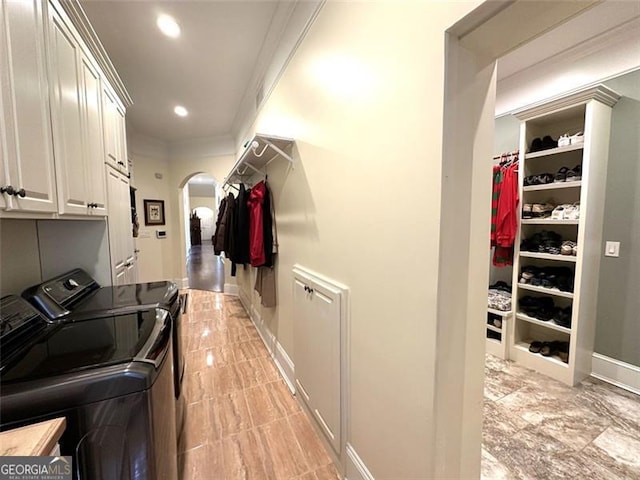 laundry room featuring cabinets, separate washer and dryer, and crown molding