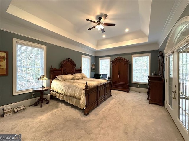 carpeted bedroom featuring access to exterior, a tray ceiling, ceiling fan, and crown molding