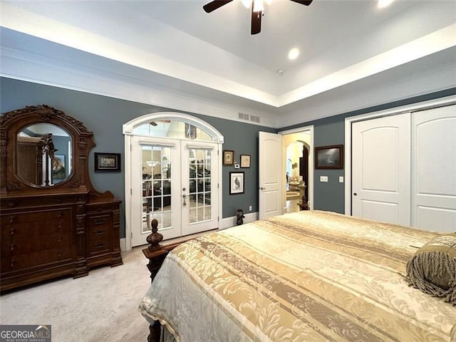 bedroom with a closet, ceiling fan, french doors, and light colored carpet