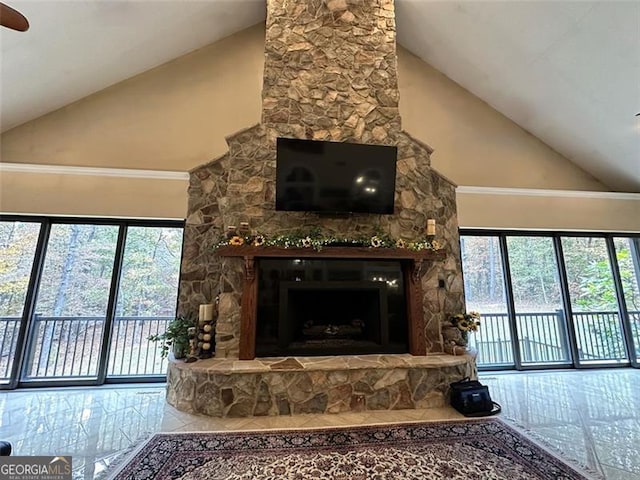 living room featuring a wealth of natural light, ceiling fan, a fireplace, and high vaulted ceiling