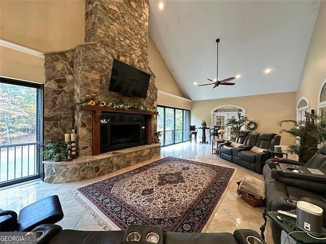 living room with a stone fireplace, ceiling fan, high vaulted ceiling, and light tile patterned floors