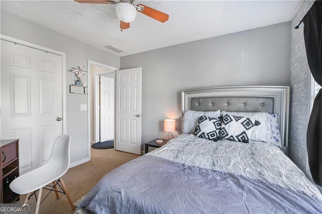 carpeted bedroom with ceiling fan and a textured ceiling