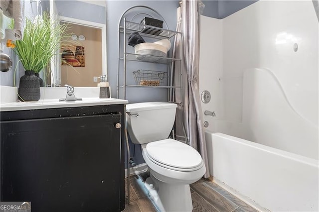 full bathroom with hardwood / wood-style floors, vanity, shower / tub combo, and toilet