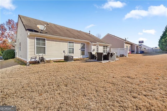 rear view of house with an outdoor living space and central AC