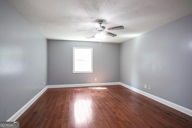 spare room with a textured ceiling, dark hardwood / wood-style floors, and ceiling fan