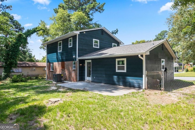 rear view of house with cooling unit, a yard, and a patio