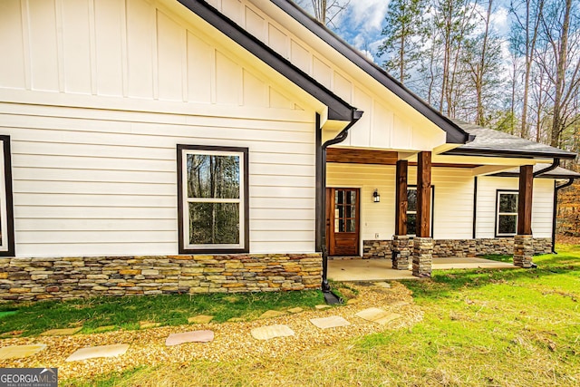 doorway to property with a yard, covered porch, and a patio area