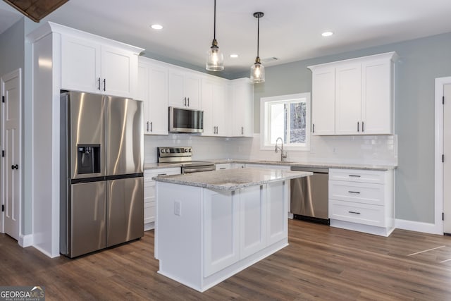 kitchen featuring sink, white cabinetry, a center island, pendant lighting, and stainless steel appliances