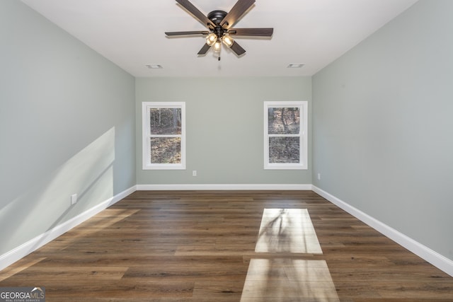 empty room with dark wood-type flooring and ceiling fan