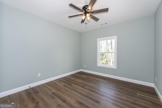 spare room with dark wood-type flooring and ceiling fan