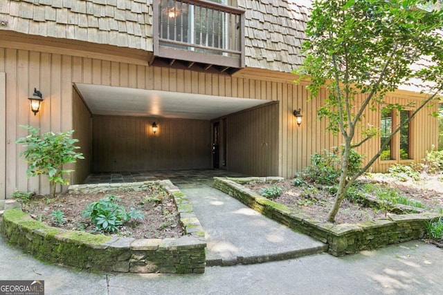 view of exterior entry with a balcony and a garage