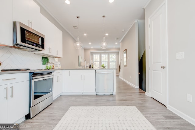 kitchen featuring light hardwood / wood-style floors, white cabinetry, pendant lighting, and appliances with stainless steel finishes