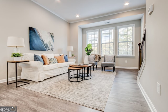 living room featuring light hardwood / wood-style flooring and ornamental molding