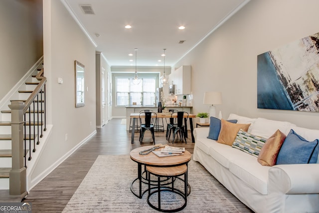 living room featuring ornamental molding and dark wood-type flooring