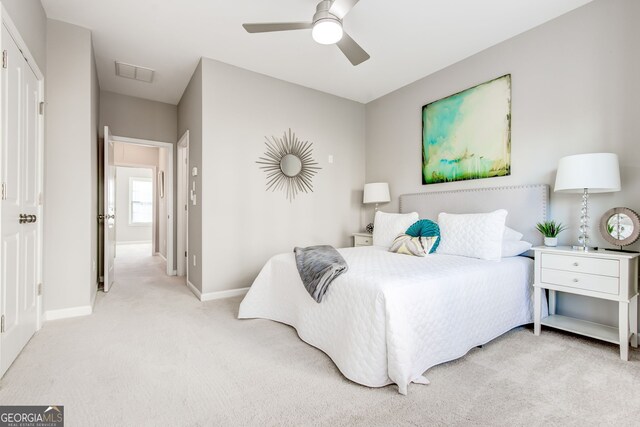 carpeted bedroom with ceiling fan and a closet