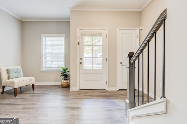 foyer entrance with crown molding and light hardwood / wood-style flooring