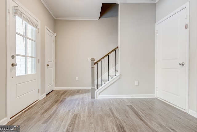 entrance foyer with light hardwood / wood-style flooring and crown molding