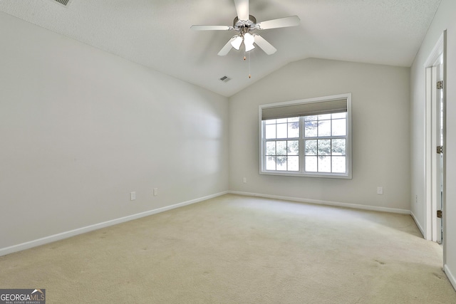 spare room with light carpet, ceiling fan, and vaulted ceiling