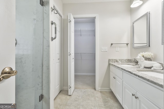 bathroom with tile patterned floors, a shower with door, and vanity