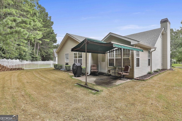 back of house featuring a lawn and a patio