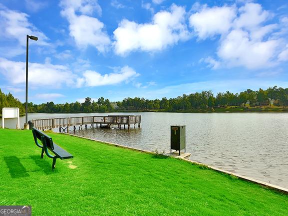 dock area with a yard and a water view