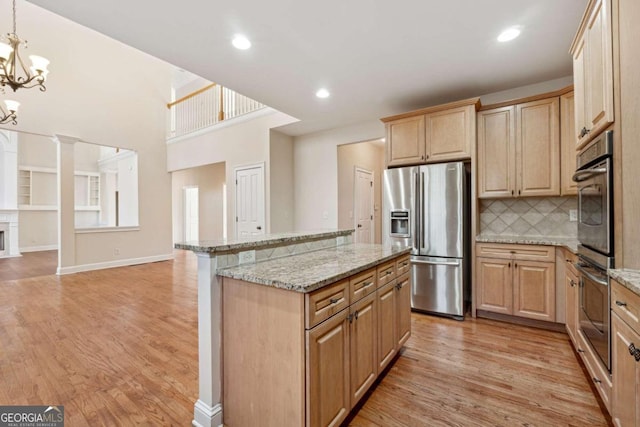 kitchen with light stone counters, light hardwood / wood-style floors, and appliances with stainless steel finishes