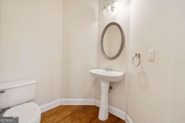 bathroom with hardwood / wood-style flooring and toilet