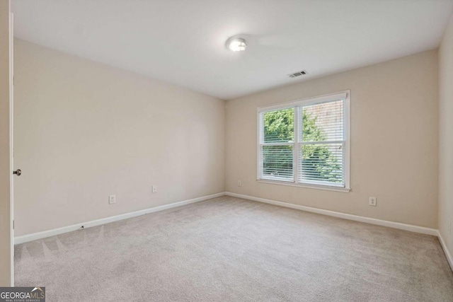 unfurnished room featuring light colored carpet