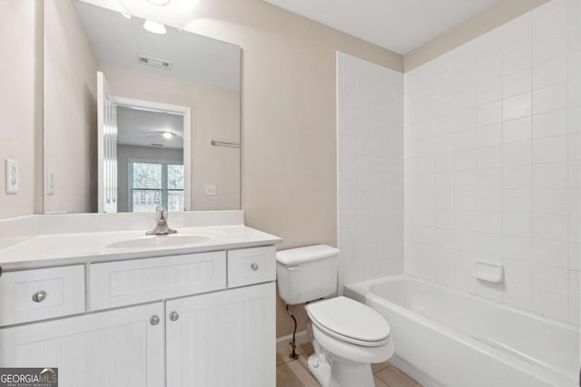 full bathroom with tile patterned flooring, vanity, tiled shower / bath combo, and toilet